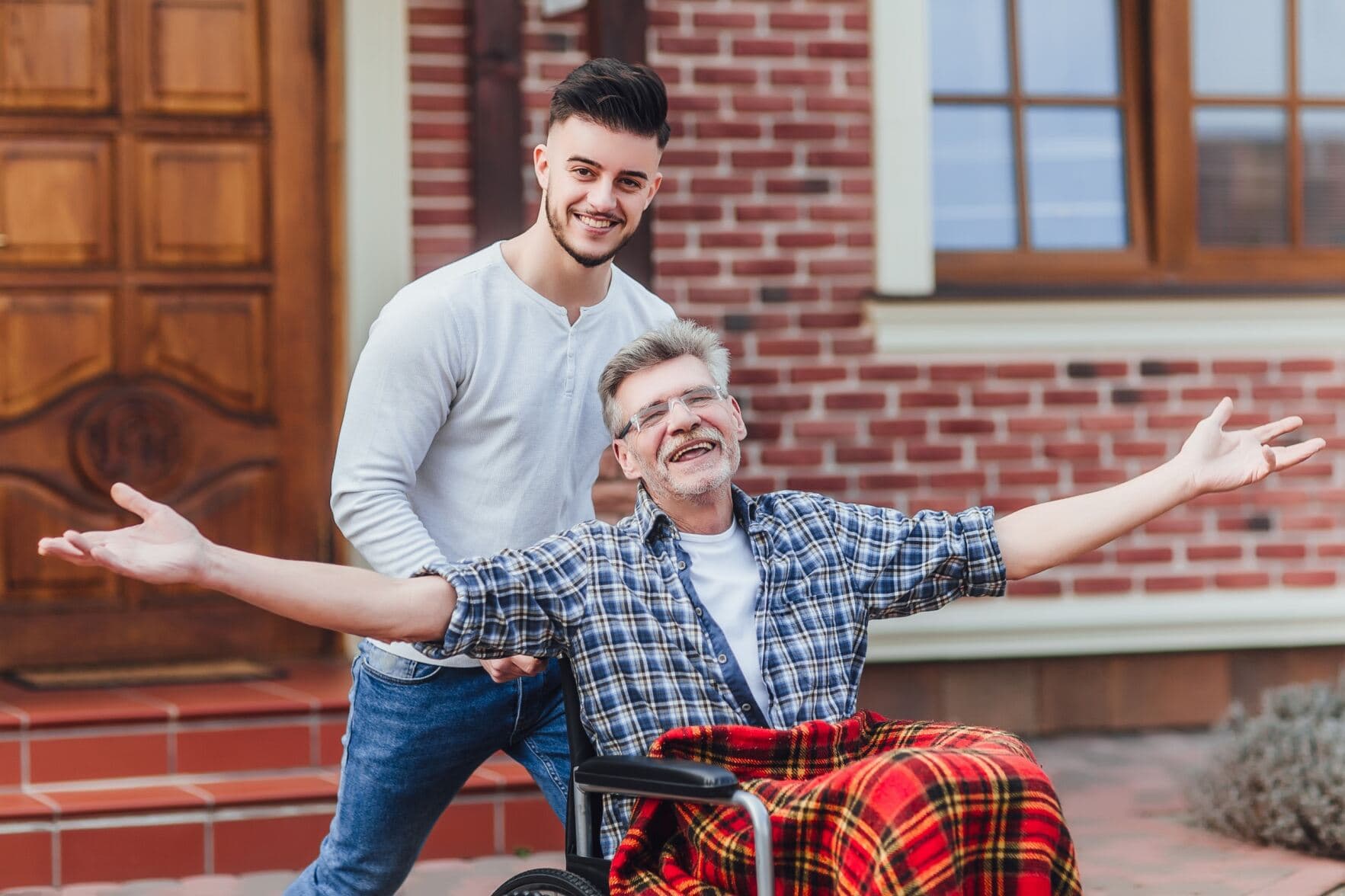 A support worker and participant sharing a joyful moment outdoors — compassionate, dignified care